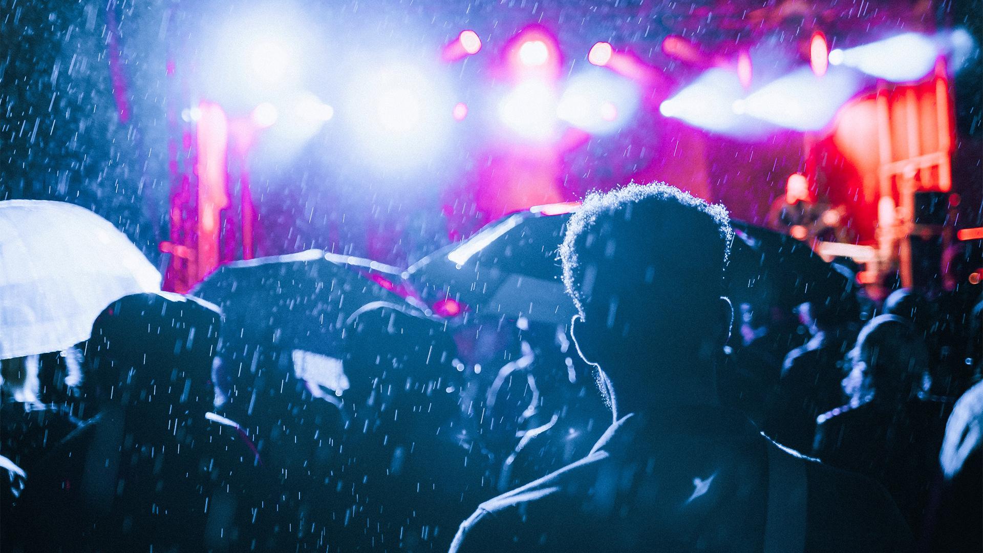 People in a concert crowd in the rain