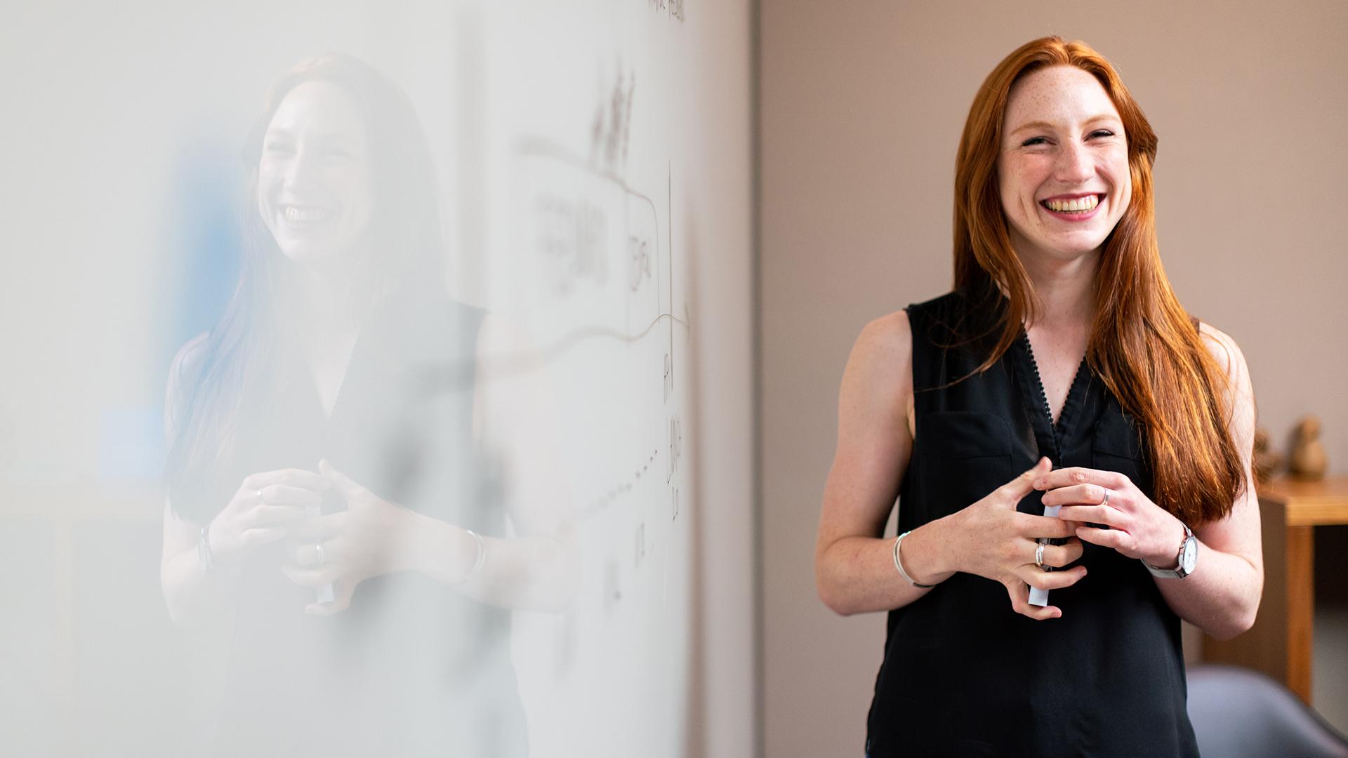 Woman standing beside whiteboard