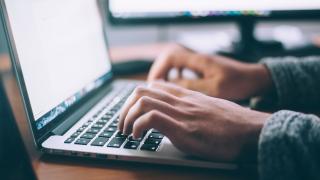 Close up of person typing on a laptop